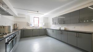 GreenheadGreenhead Hostel的一间大厨房,配有灰色的橱柜和电器