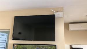 乌巴图巴Casa Ubatuba的挂在墙上的大屏幕平面电视