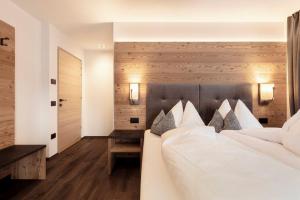 塞尔瓦迪加尔代纳山谷Chalet Miriam的卧室配有带白色枕头的大床