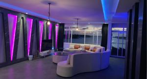 杜拉特阿拉尔شاليه درة العروس的带沙发和电视的客厅以及紫色照明
