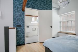 栋堡Hello Zeeland - Appartement Weststraat 36的一间卧室设有一张床和一间浴室。