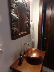 圣博尼法西乌Caminhos da Serra do Tabuleiro - Chalé do Lago的木柜台上带铜水槽的浴室