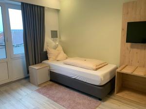 霍鲁梅尔希尔施密特霍恩酒店的一间小卧室,配有一张带窗户的床