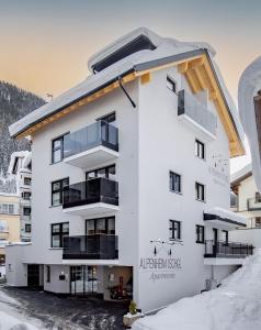 伊施格尔Alpenheim Apartment Ischgl的雪中白色公寓大楼