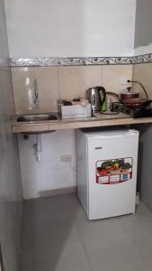萨利纳斯Habitacion Vacacional Camboriu的一个带水槽和白色冰箱的小厨房
