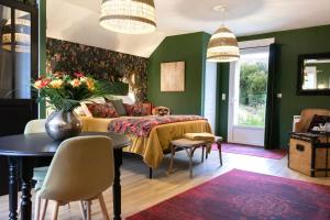 武夫赖Les Patis的一间卧室设有绿色的墙壁和一张带桌椅的床。