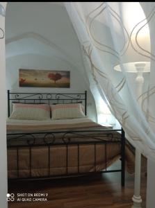 图列Il Nido della Calandra的一间卧室配有一张白色天蓬床