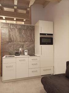 MaurachZimmer bei Landhaus Mayr的厨房配有白色橱柜和冰箱。