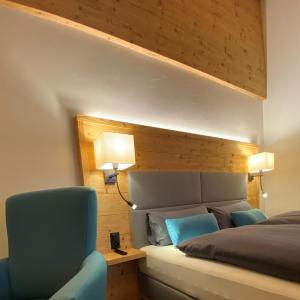 布赖尔Adults Only Hotel Mulin - Das Erwachsenen-Hotel in den Bergen的一间卧室配有一张床和一张蓝色椅子