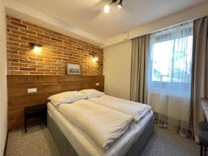 托伦温尼卡旅馆的一间卧室设有一张床和砖墙