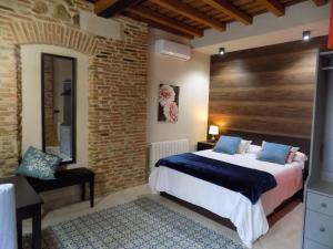普拉森西亚Apartamentos Suite Puerta del Jerte的一间卧室设有一张床和砖墙
