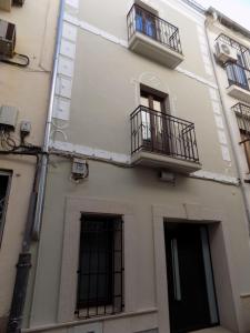 普拉森西亚Apartamentos Suite Puerta del Jerte的一座建筑,设有两个阳台和两个窗户