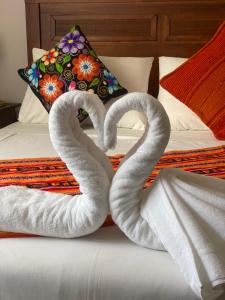 圣何塞德迈波Refugio del Maipo Lodge的床上的两条毛巾天鹅