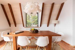 科帕奥尼克Vista Mountain House的一间带木桌和白色椅子的用餐室