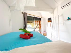 班泰Sea Love Beach Bar & Bungalows的一张带两个红色枕头的床,上面有植物