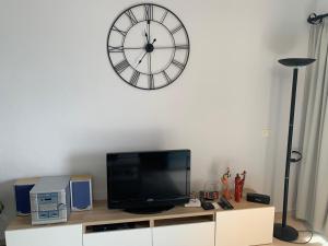 卡亚俄萨尔瓦赫Superbe appartement avec vue sur l océan的壁橱上的电视,墙上有时钟