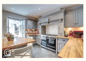 斯沃尼奇Charming 3-Bed Cottage in Swanage的厨房配有白色橱柜和木桌
