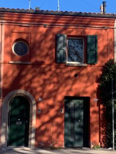里米尼La casetta rossa的红砖建筑,有两扇门和一扇窗户
