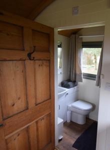 查尔德Forton House Shepherd's Huts的一间带卫生间和木门的浴室