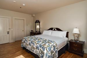 Port Hood山顶会堂乡村宾馆的一间卧室配有一张床和一张带台灯的桌子
