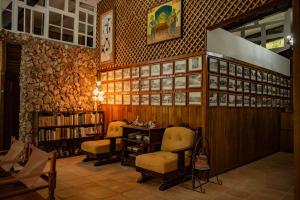 圣何塞Exclusive Hotel Don Ernesto By La Chimba的图书馆配有两把椅子、一张桌子和书籍