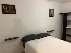 ChiconcuacCasa en Oasis en Xochitepec的卧室配有一张床,墙上挂有两张照片