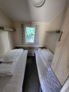 布莱克浦Caravan Kensington 46 at Marton Mere Blackpool的小型客房 - 带2张床和窗户