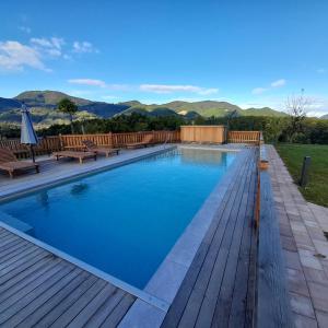 罗加斯卡斯拉提纳马尔雅加观光农场酒店的一座带木甲板的游泳池,其背景是山脉