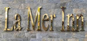 科泽科德La Mer Inn的石墙上写有金色博物馆的标志