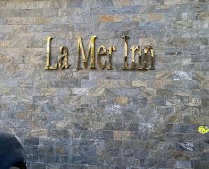 科泽科德La Mer Inn的砖墙上的一个标牌,上面写着毛线