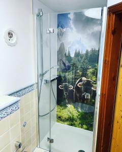 内森尔旺兰德加斯霍夫足奥坦莱辛巴赫酒店的浴室设有淋浴,并画有一幅牛的画作