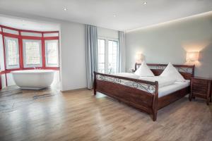 恩斯特安德鲁别墅酒店的一间卧室设有一张大床和一个浴缸