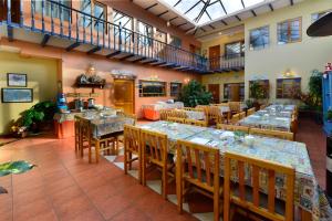 昆卡Hotel Posada del Angel的大型用餐室配有桌椅
