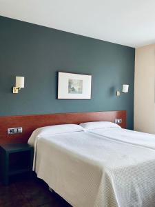 艾丝黛拉耶尔丽酒店的一间卧室设有两张床和蓝色的墙壁