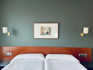 艾丝黛拉耶尔丽酒店的卧室配有两张床,墙上挂着一幅画