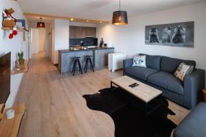 克莱恩 蒙塔纳Magnifique appartement proche du centre et du ski的客厅配有蓝色的沙发和桌子