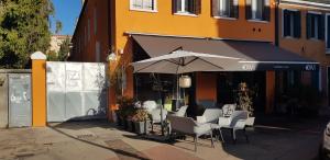 帕多瓦Borgo Portello的大楼前的桌椅和遮阳伞