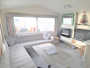 米勒姆3 Bedroom Modern Caravan Sleeps up to 8的客厅配有白色的沙发和桌子