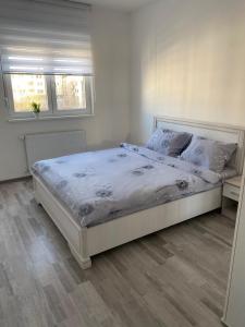 巴尼亚科维利亚查Apartmani Milić Banja Koviljača的卧室配有一张带白色床单和枕头的大床。