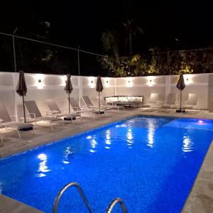 布塞里亚斯Villas Frida Kahlo的夜间游泳池,配有椅子和桌子
