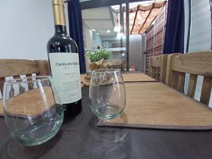 卢汉德库约Hermoso Departamento En Lujan De Cuyo Mendoza的桌子上放有一瓶葡萄酒和两杯酒