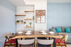 科塔达曼萨拉Encorp Strand Residences by Airhost的一间带木桌和椅子的用餐室