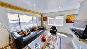 摩押Moab Flats #1的客厅配有真皮沙发和电视