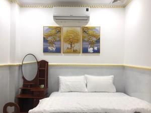 朔庄Khách Sạn Mỹ Hằng的卧室的墙上装饰有四幅画作
