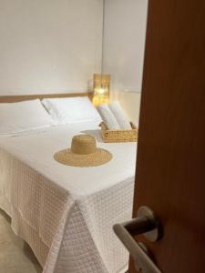 佩德拉斯港Patacho Beach - Milagres - Rota Ecológica的稻草帽坐在床上