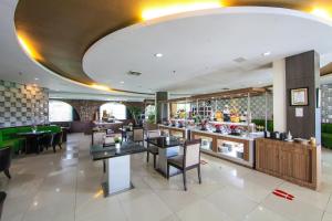 芝勒贡皇家喀拉喀托酒店的一间带桌椅的餐厅和一间酒吧
