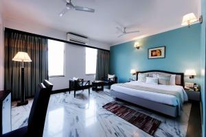 兰奇国会大厦公寓酒店的一间卧室设有一张大床和蓝色的墙壁