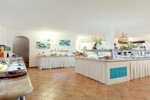 奥罗塞伊Sentido Orosei Beach的一间大厨房,内设柜台和桌子