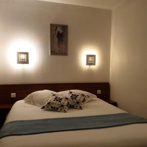 孔卡尔诺所有海洋餐厅酒店的一张带两个枕头的床和墙上的两盏灯