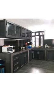 Centre de FlacqSunrise Sensation holiday home.的厨房配有黑色橱柜和微波炉